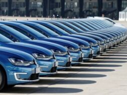 People walk pasta row of Volkswagen e-Golf cars during the company’s annual news conference in Berlin