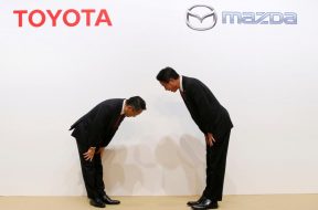 Toyota Motor President Akio Toyoda and Mazda Motor President Masamichi Kogai bow at a joint news conference in Tokyo