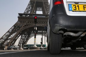 A car drives near the Eiffel tower in Paris during unusually high levels of pollution in France