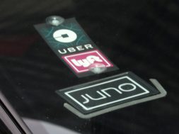 The Uber Lyft and Juno logos are seen on a car as it drive up 6th Avenue in New York City