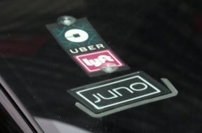 The Uber Lyft and Juno logos are seen on a car as it drive up 6th Avenue in New York City