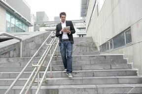 man-walking-down-stairs-tablet-footage-014830136_prevstill