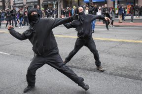 Protestors throw rocks at police during a protest near the inauguration of President Donald Trump in Washington