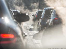 Blurred silhouettes of cars surrounded by steam from the exhaust