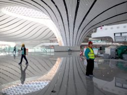 Construction workers are seen inside the terminal hall of the Beijing Daxing International Airport under construction in Daxing district, Beijing