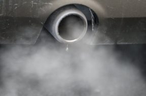 An exhaust emits fumes as a car is driven through Richmond in London