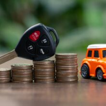 Car key on money coin with car model on table, Sell and Buy car concept.