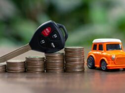 Car key on money coin with car model on table, Sell and Buy car concept.