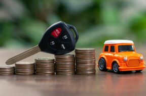 Car key on money coin with car model on table, Sell and Buy car concept.