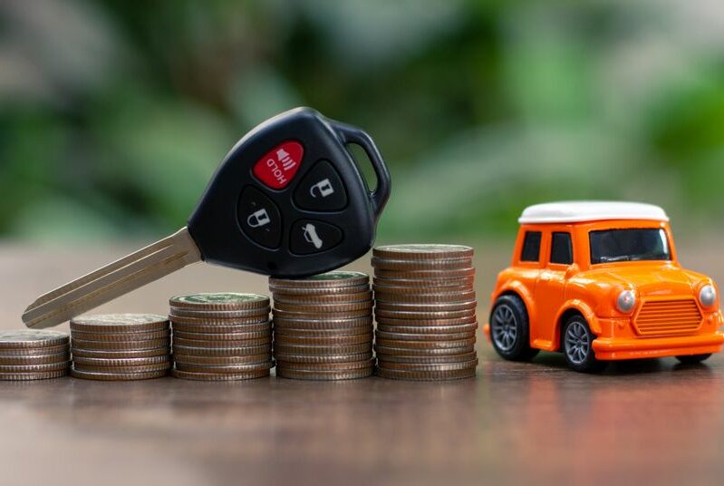 Car key on money coin with car model on table, Sell and Buy car concept.