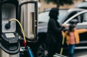 Cable connected to electrical outlet at car charging station
