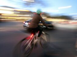 Radfahrer radelt auf einer Straße in der Innenstadt von Heidelberg und wird von einem Auto überholt, Baden Württemberg,