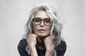 Lady-with-long-grey-hair-wearing-round-black-glasses