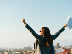 Business Woman Celebrating Success Towards City Skyline